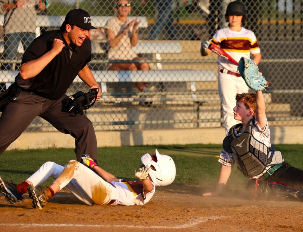 Youth baseball play at home plate