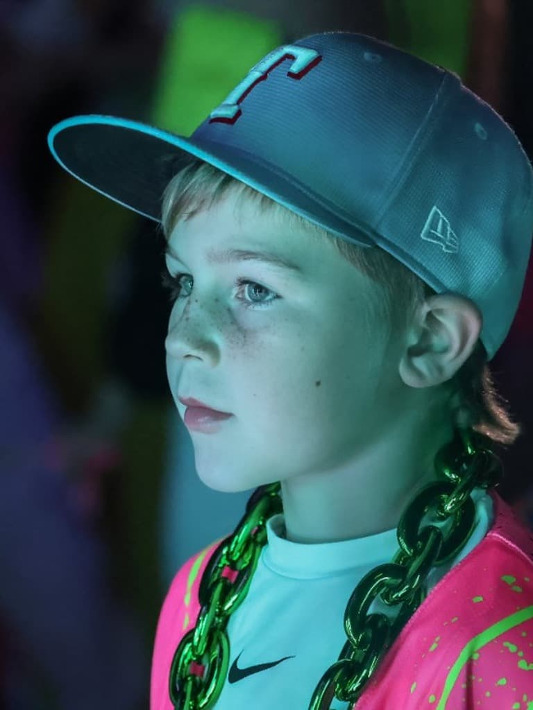 Young baseball player in a neon pink jersey and cap